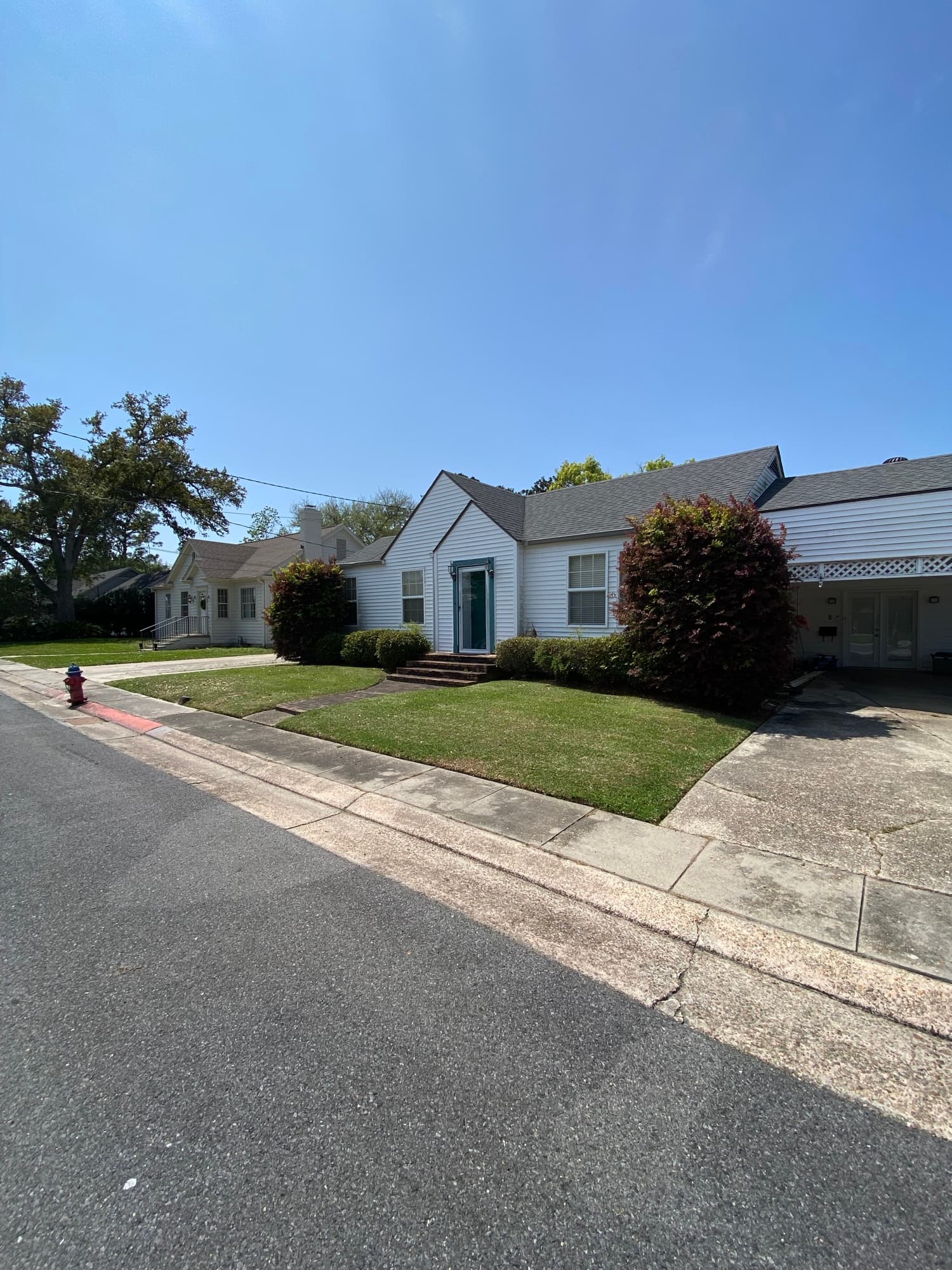 White home with a freshly mowed lawn maintained by TIMCO