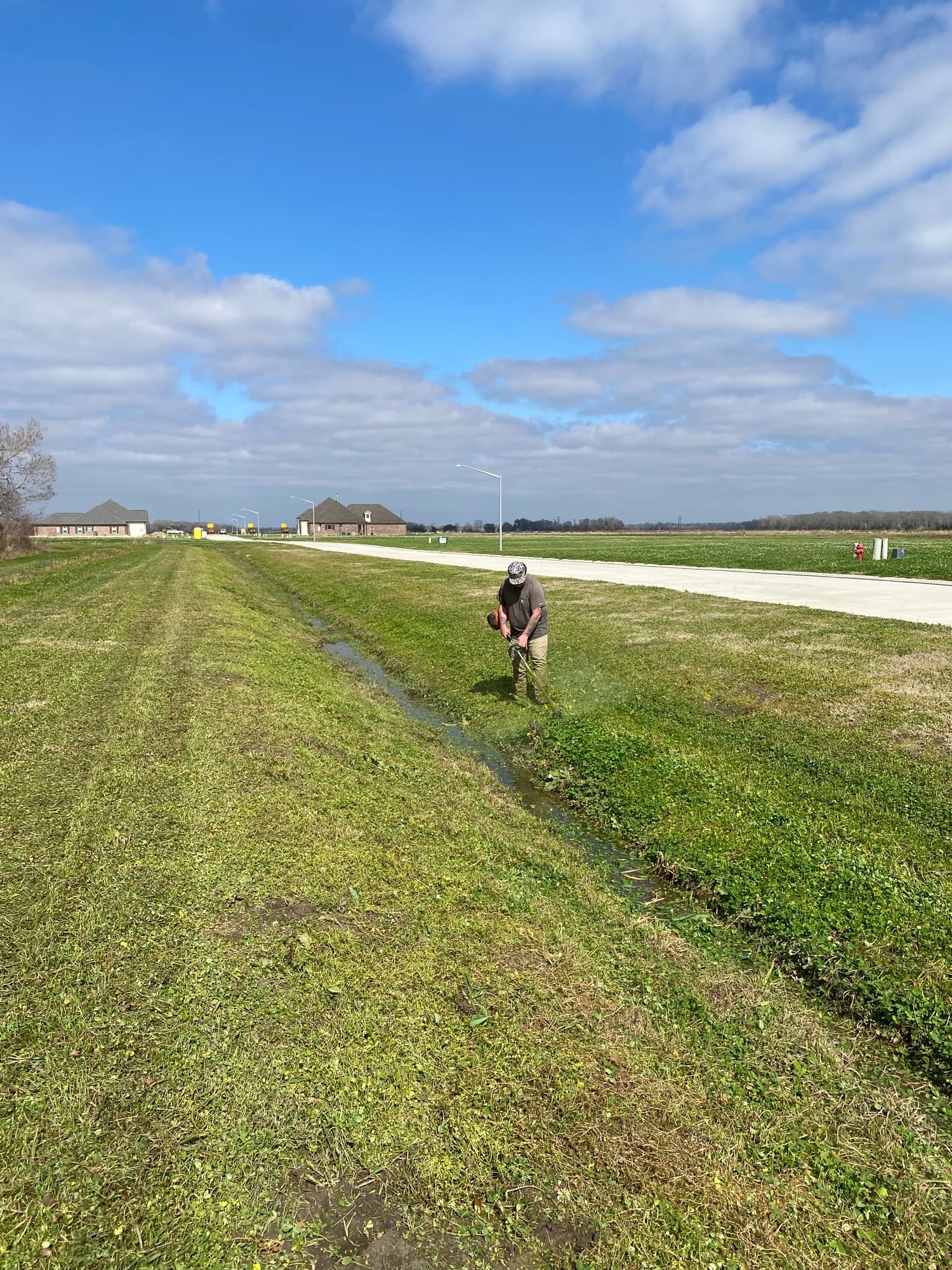 TIMCO crew weed eating along a commercial grounds edge